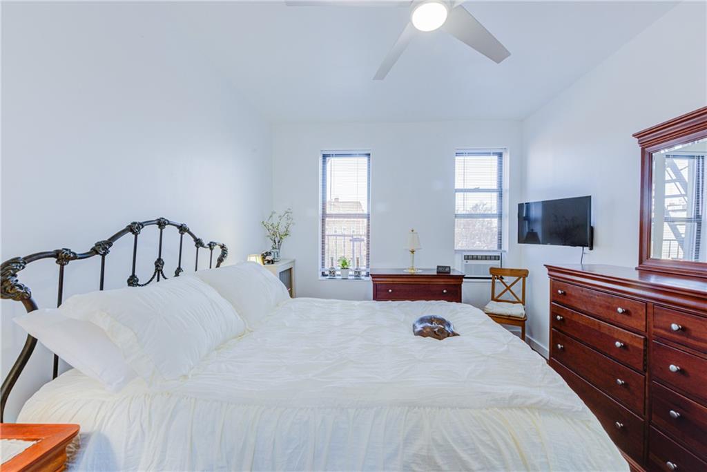 255 79th Street, Unit E11 Brooklyn, NY 11209 - Photo 24 of 34 a bedroom with a bed and a flat tv screen on dresser