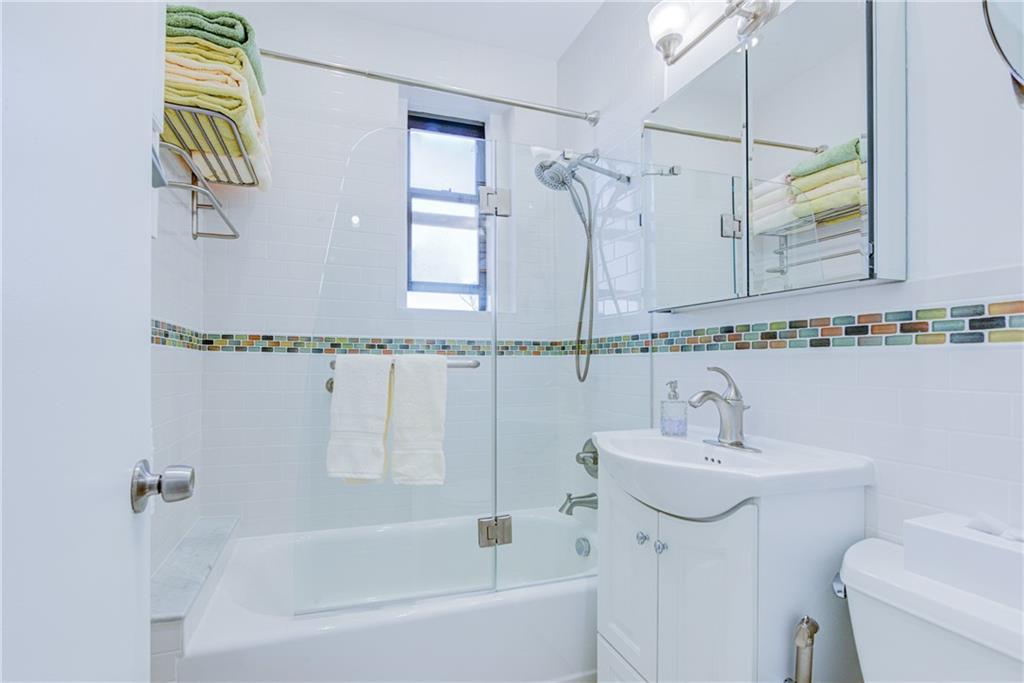 255 79th Street, Unit E11 Brooklyn, NY 11209 - Photo 31 of 34 a bathroom with a sink and a mirror