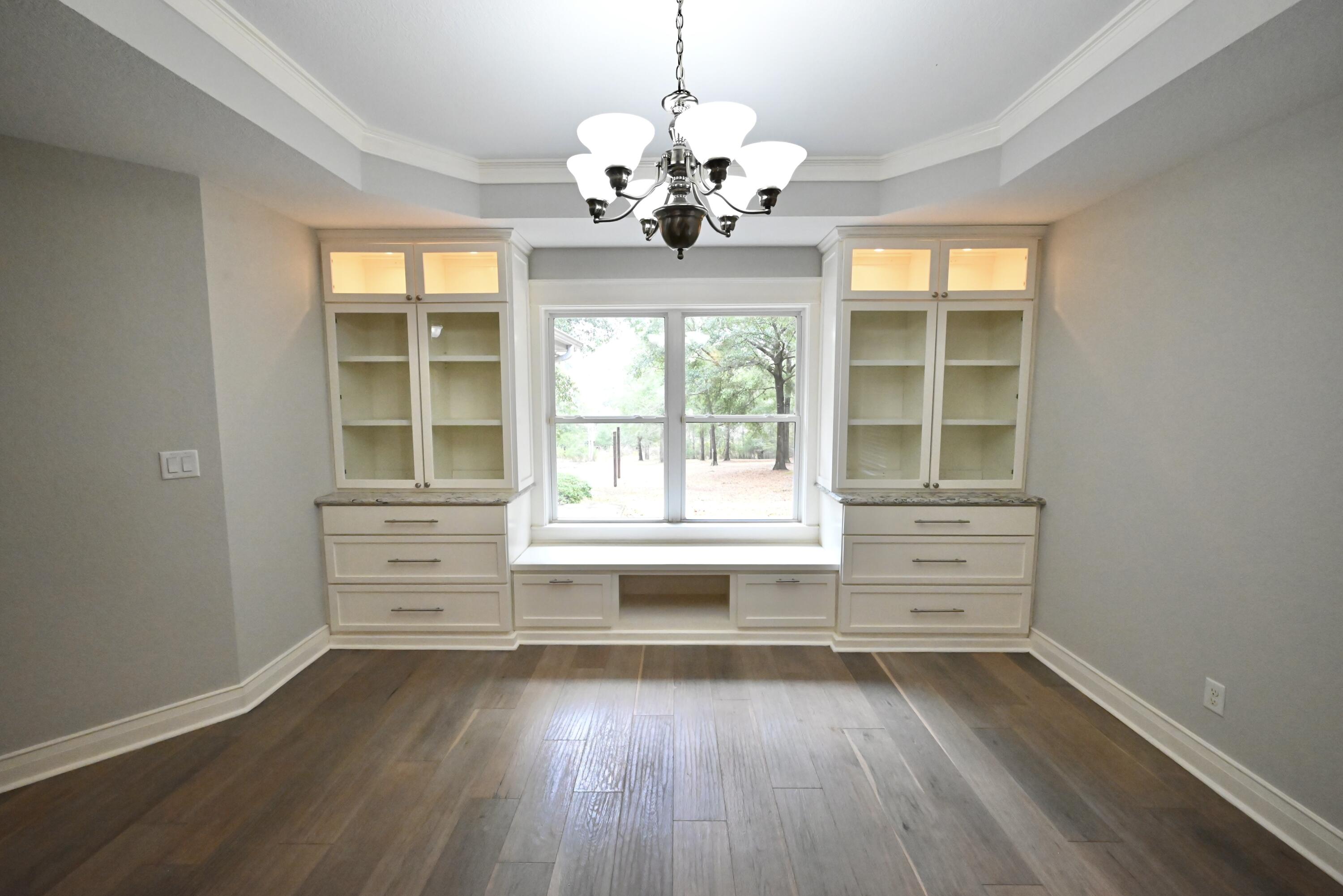 202 Shell Drive Crestview, FL 32536 - Photo 9 of 38 wooden floor in an empty room with a window