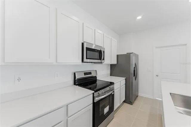 a kitchen with stainless steel appliances a refrigerator sink and microwave