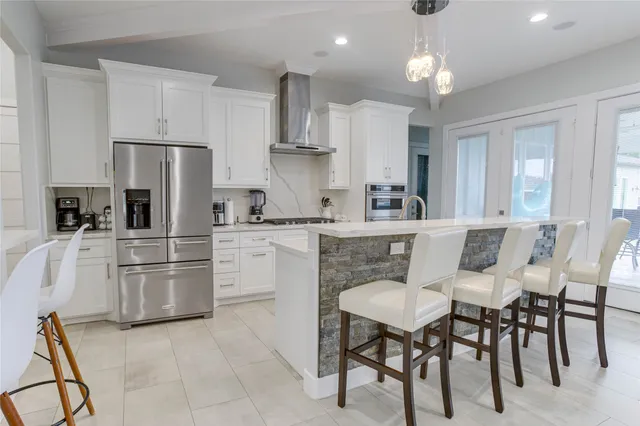 a kitchen with refrigerator cabinets dining table and chairs