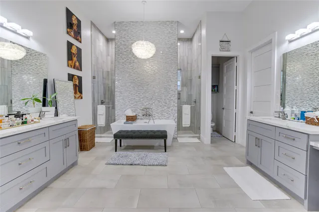 a spacious bathroom with a granite countertop sink mirror and bathtub