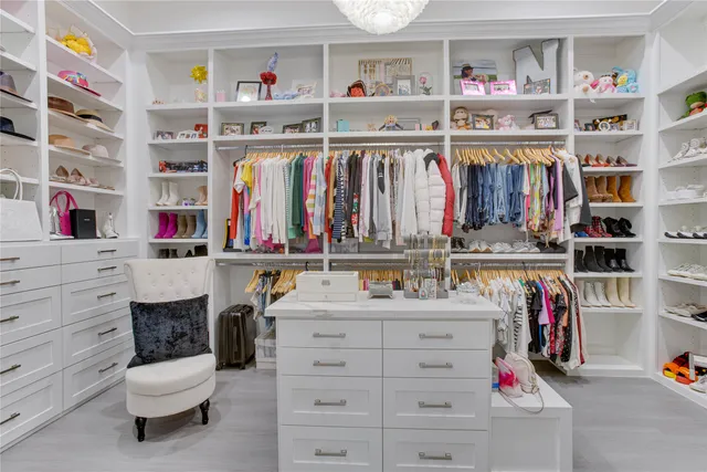a view of walk in closet with clothes and shoes