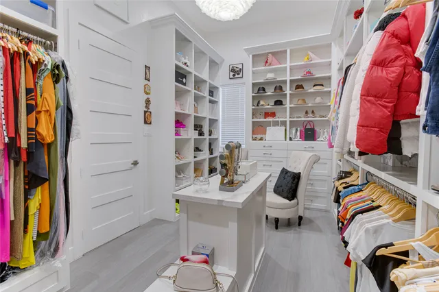 a view of walk in closet with clothes and shoes