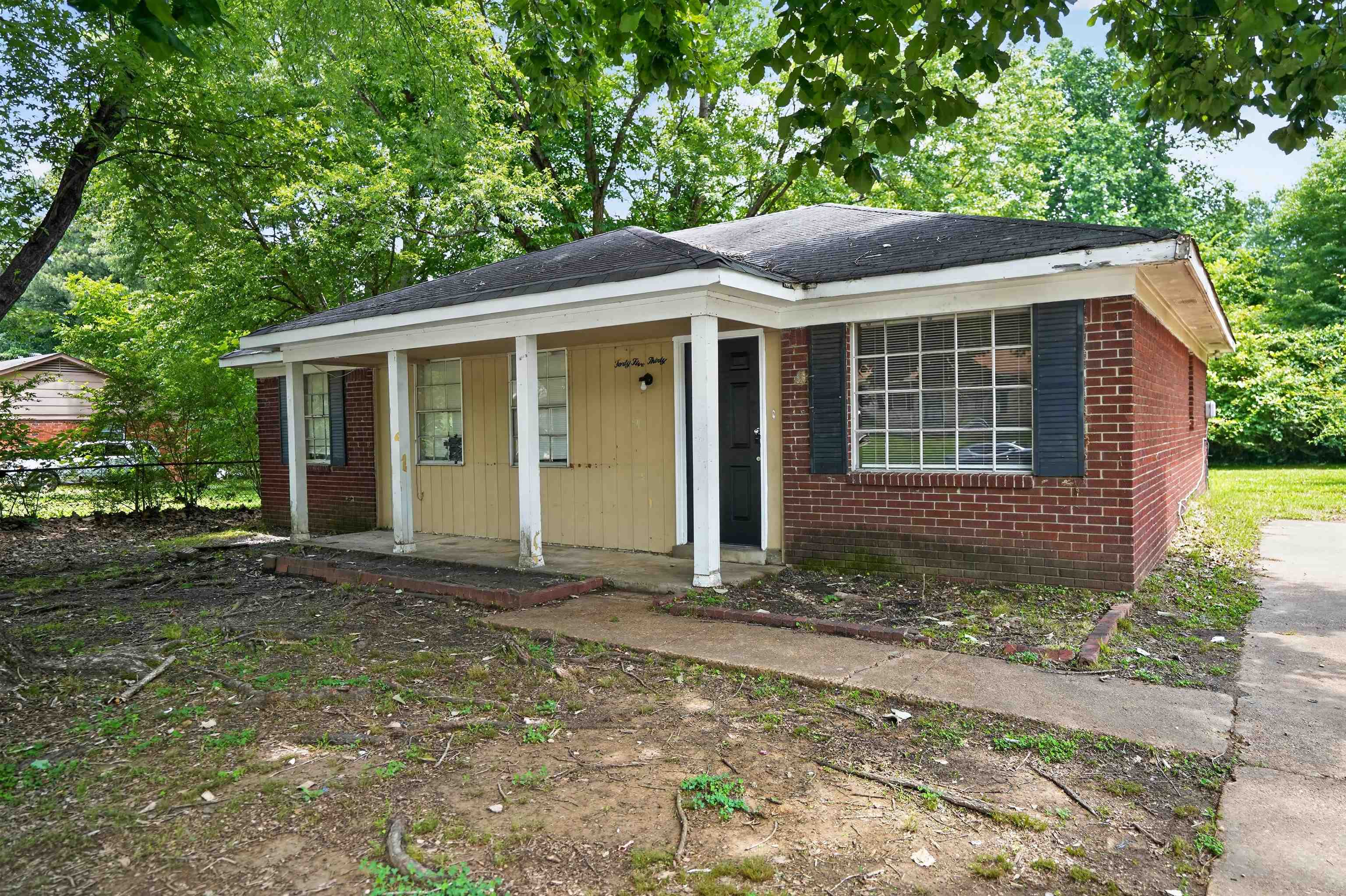4530 Spring Valley Drive Memphis, TN 38128 - Photo 2 of 15 Brick exterior with a covered porch entry, white window trim, dark shutters, and a concrete walkway