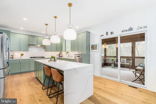 a large kitchen with kitchen island a large island in it