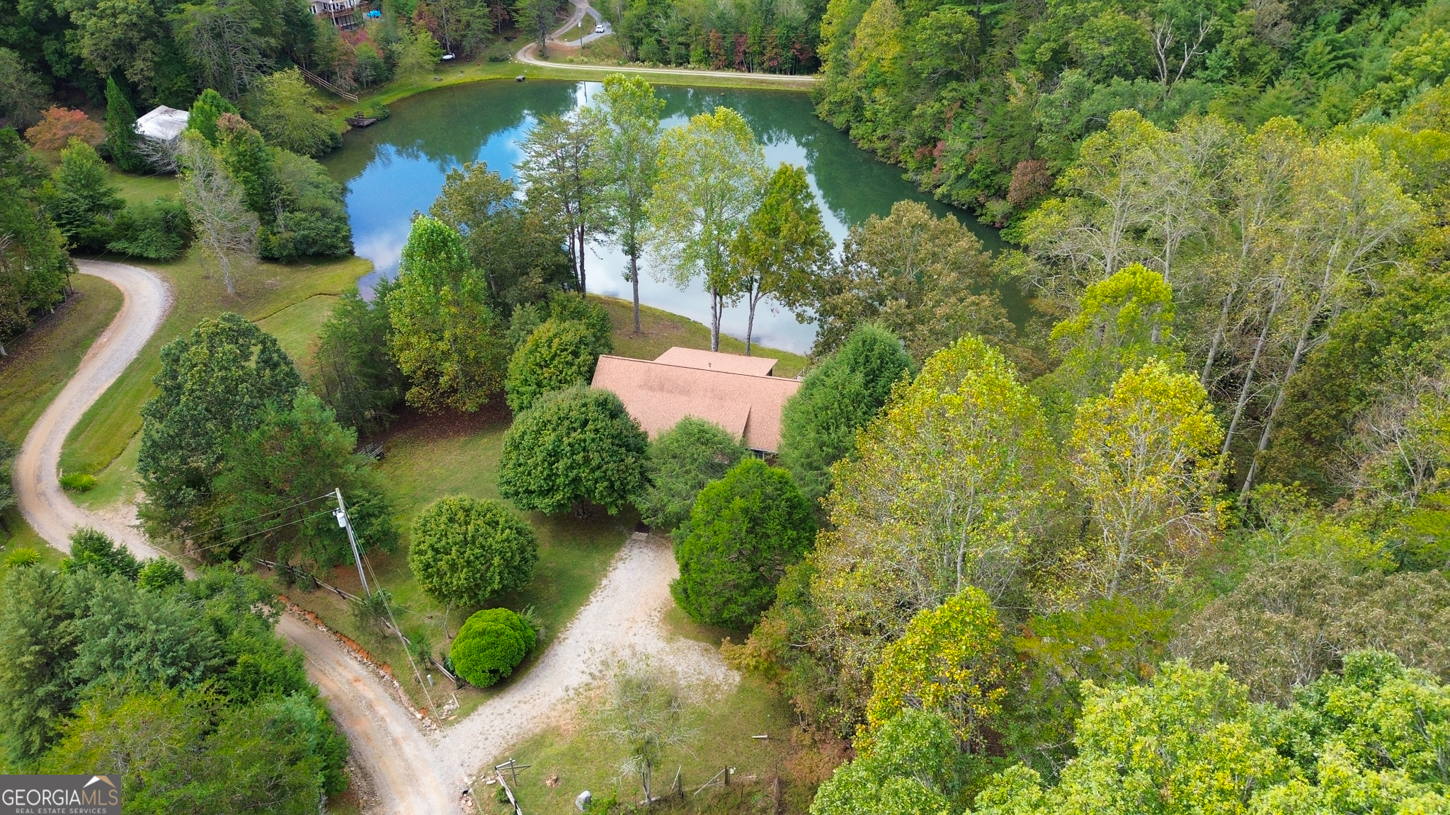 an aerial view of residential houses with outdoor space and trees
