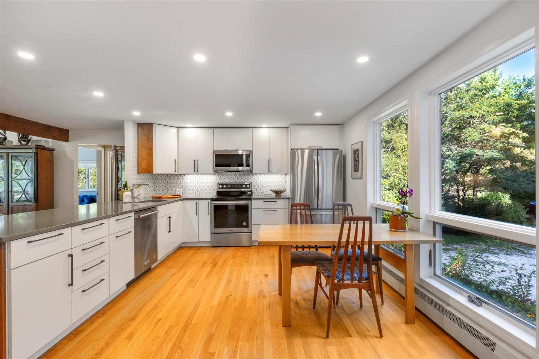 225 Coles Neck Road Wellfleet, MA 02667 - Photo 11 of 51 a large kitchen with lots of counter space wooden floor stainless steel appliances and windows