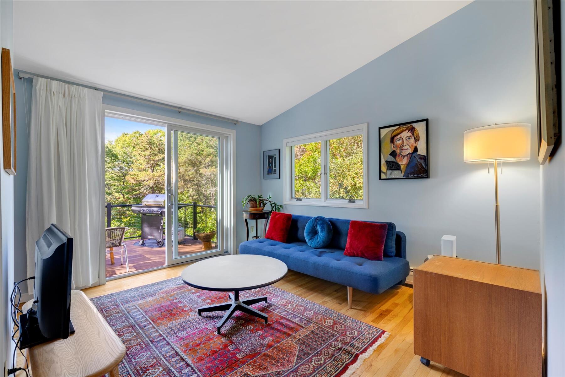 225 Coles Neck Road Wellfleet, MA 02667 - Photo 33 of 51 a living room with furniture a rug a lamp and a fireplace