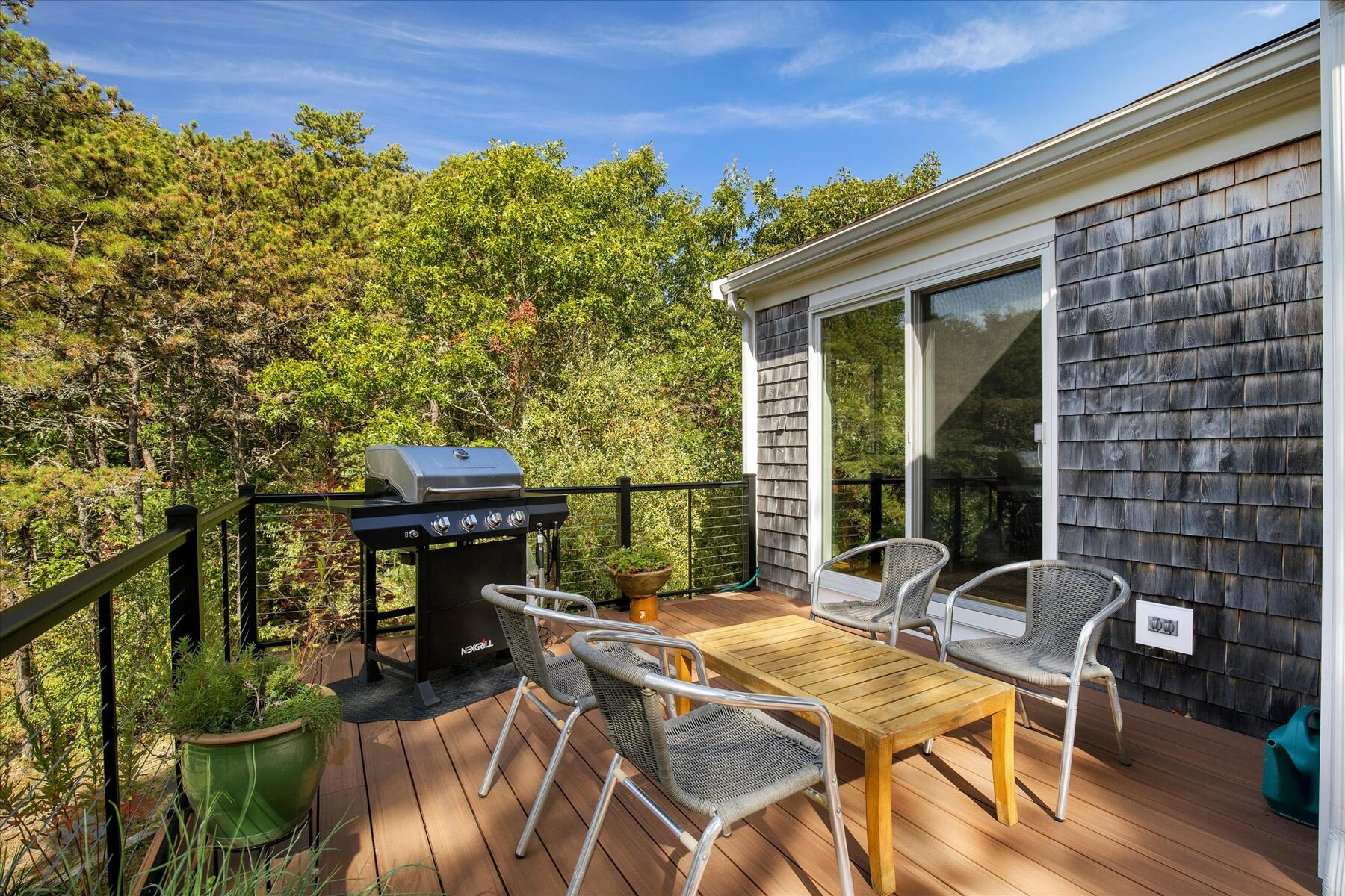 225 Coles Neck Road Wellfleet, MA 02667 - Photo 40 of 51 a view of a patio with a table chairs and a potted plant