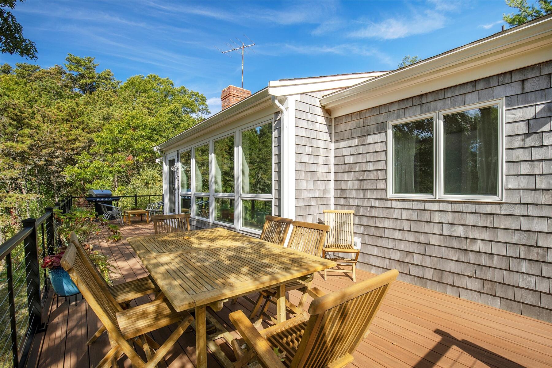 225 Coles Neck Road Wellfleet, MA 02667 - Photo 44 of 51 a view of a patio with table and chairs with wooden floor and fence