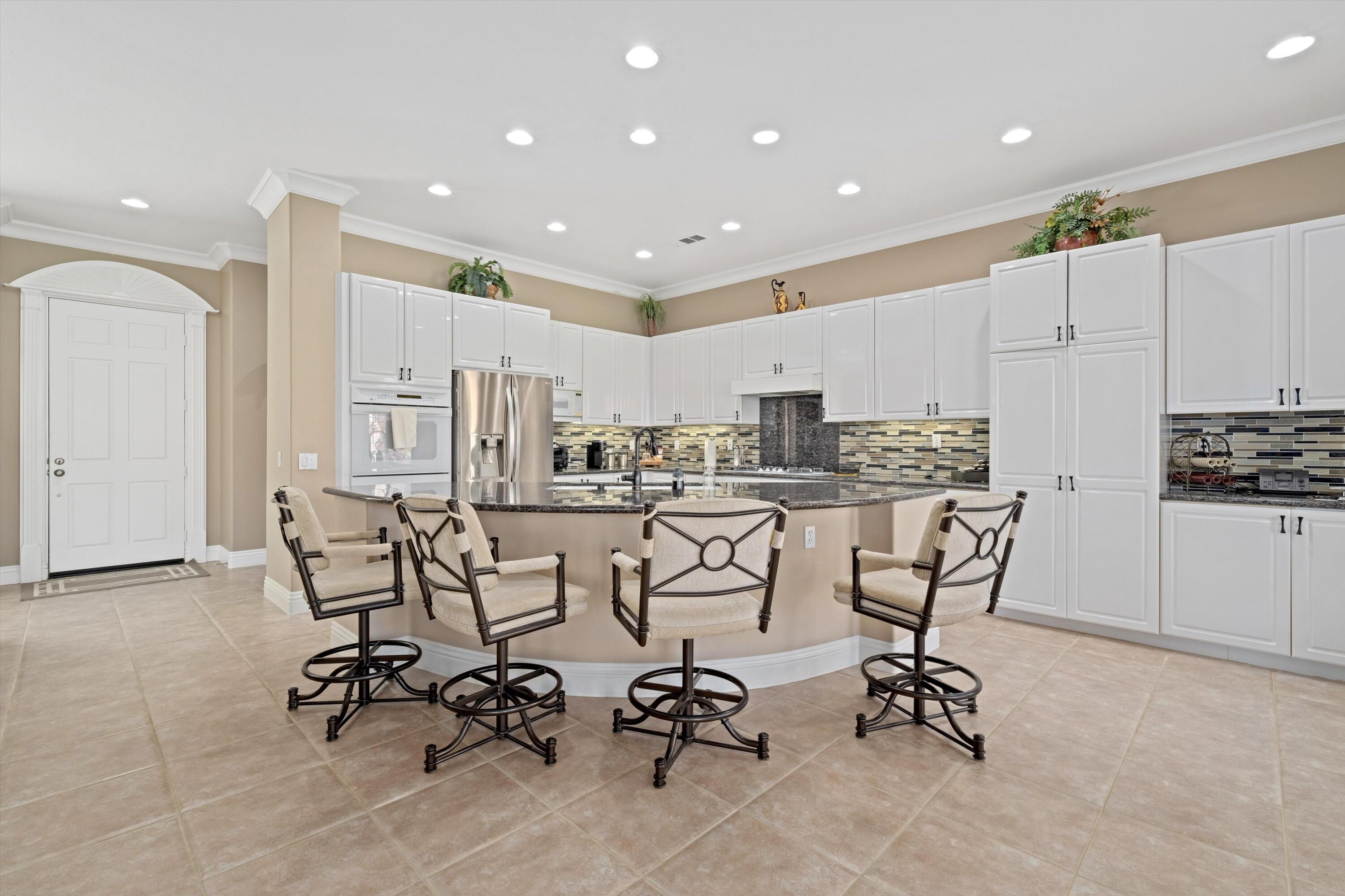 57255 Interlachen La Quinta, CA 92253 - Photo 20 of 34 a view of a kitchen with kitchen island and a dining table chairs