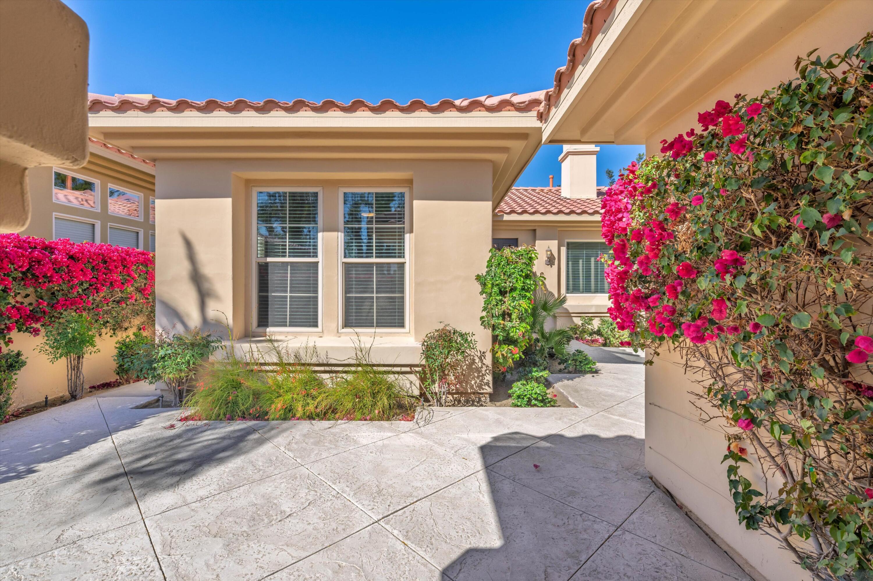 57255 Interlachen La Quinta, CA 92253 - Photo 9 of 34 a front view of a house with a yard and flowers