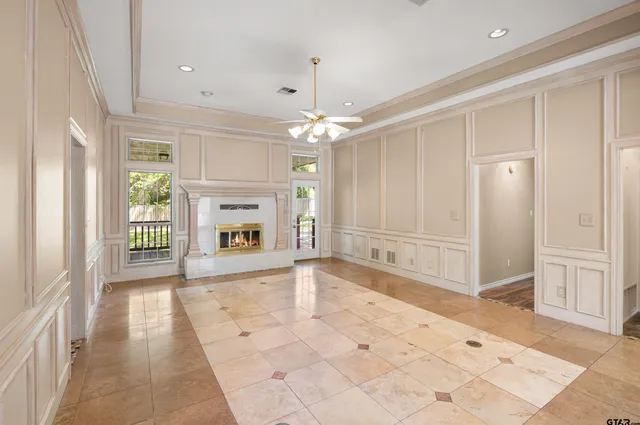 a view of an empty room with window and chandelier