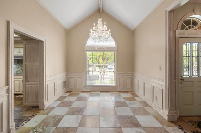 a view of a hallway with windows and chandelier