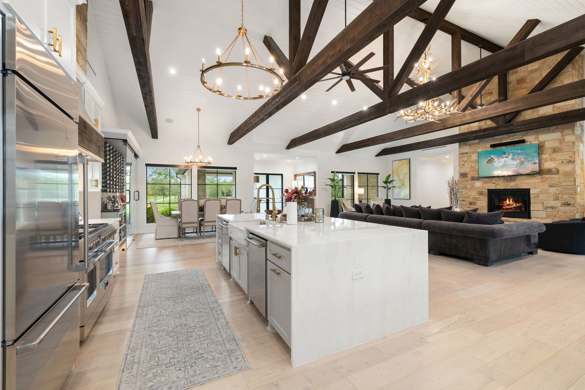 1100 Felder Road Washington, TX 77880 - Photo 15 of 50 The island with farmhouse sink and dishwasher keeps this open-concept kitchen functional at scale, with clear sightlines to the dining area and living room beyond, ideal for hosting and everyday connectivity.