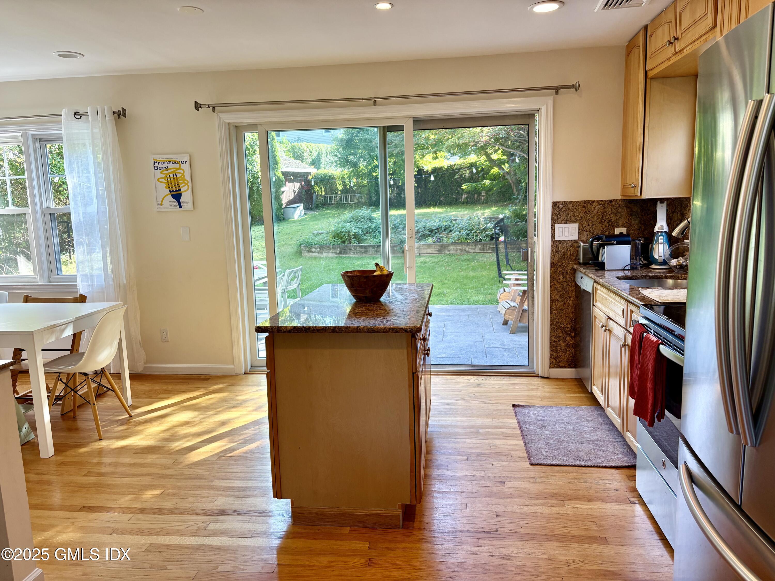 19 Wescott Street Riverside, CT 06878 - Photo 8 of 21 a kitchen with stainless steel appliances granite countertop a refrigerator a stove top oven a large window with wooden floor and garden view