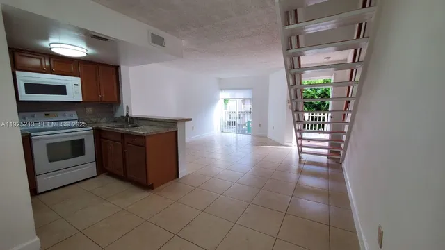 a kitchen with granite countertop a stove top oven and sink