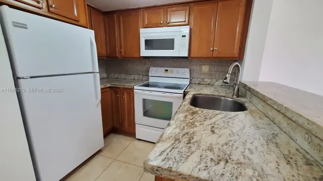 a kitchen with a refrigerator sink and cabinets