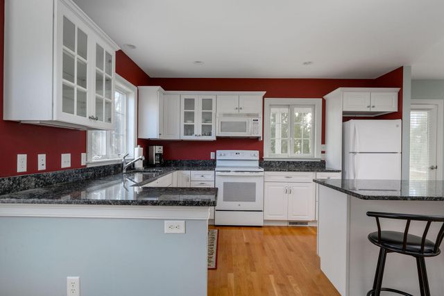 a kitchen with stainless steel appliances granite countertop a stove a sink and a white cabinets