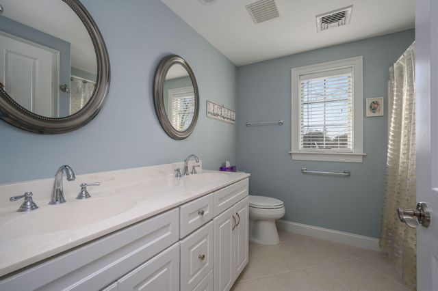a bed sitting in a spacious bedroom next to a window