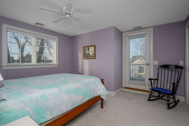 a bedroom with a bed lamp and a large window