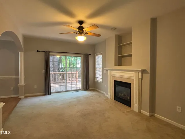 a view of a livingroom with a fireplace and a ceiling fan