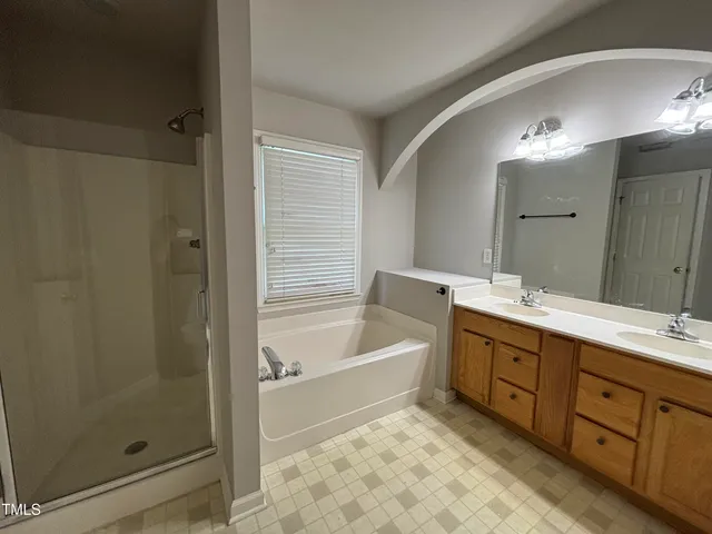 a bathroom with a tub sink shower and mirror