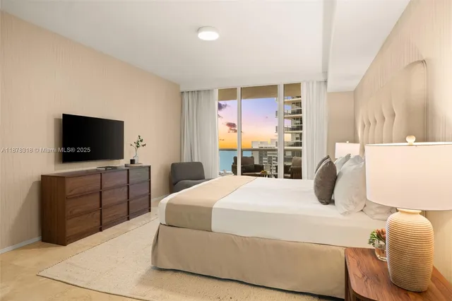 a bedroom with a bed and a flat screen tv