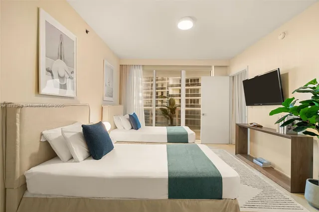 a bedroom with a large bed and a flat tv screen