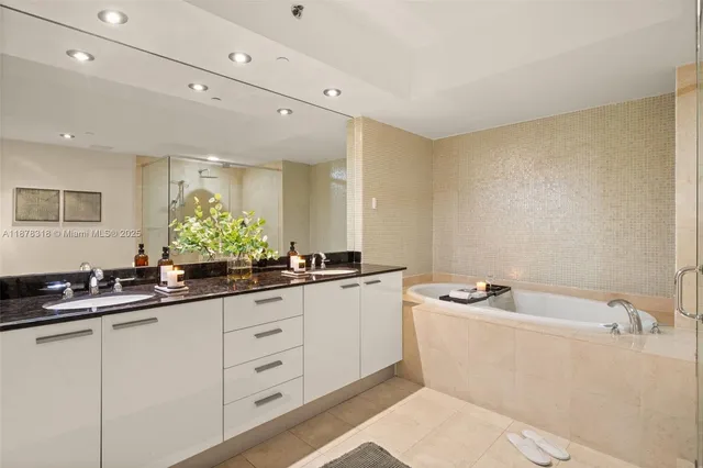 a bathroom with a sink a large mirror and a bathtub
