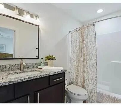 a bathroom with a granite countertop sink and a mirror