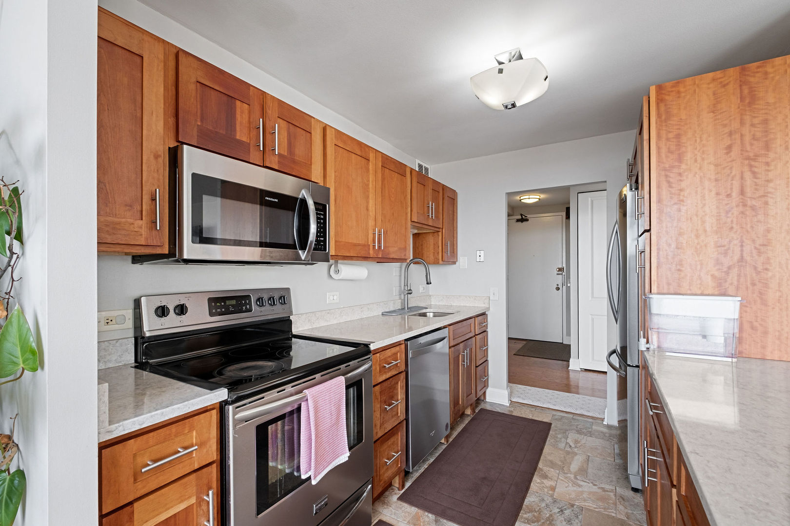 5445 North Sheridan Road, Unit 802 Chicago, IL 60640 - Photo 11 of 32 a kitchen with stainless steel appliances a stove a sink and a microwave