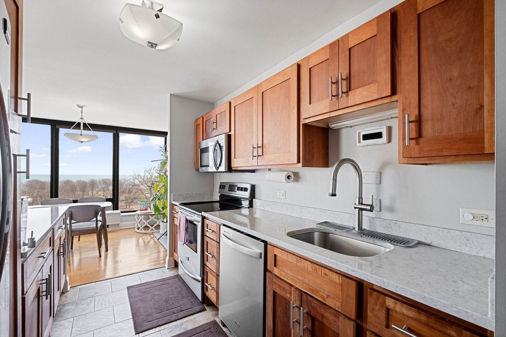 5445 North Sheridan Road, Unit 802 Chicago, IL 60640 - Photo 13 of 32 a kitchen with stainless steel appliances granite countertop a sink a stove and cabinets