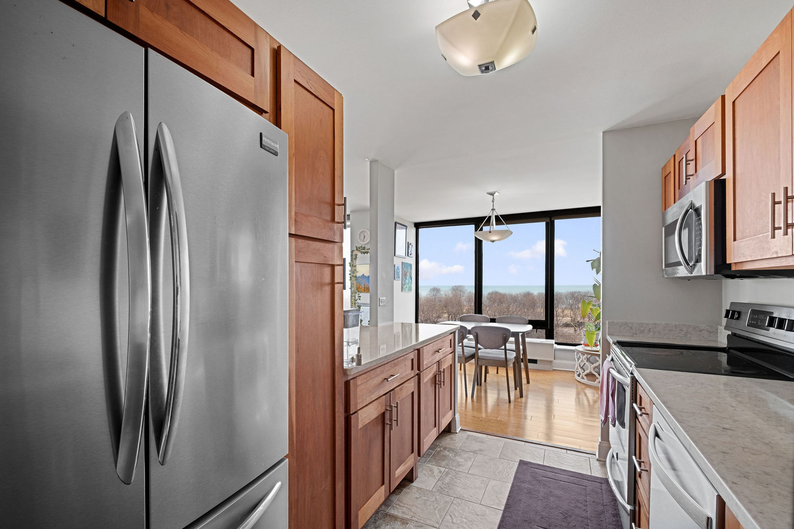 5445 North Sheridan Road, Unit 802 Chicago, IL 60640 - Photo 14 of 32 a kitchen with stainless steel appliances granite countertop a refrigerator a stove and a sink with granite countertops