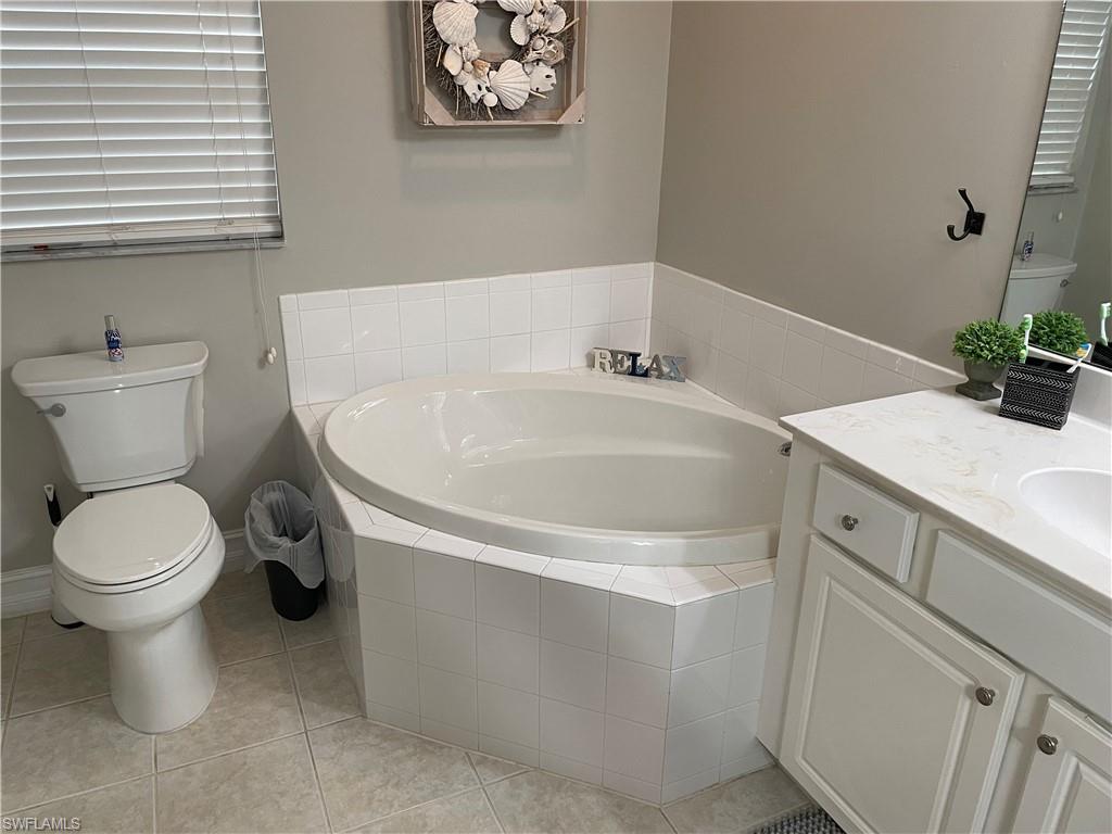 9195 Michael Circle, Unit 1301 Naples, FL 34113 - Photo 19 of 25 a white bath tub sitting next to a white toilet