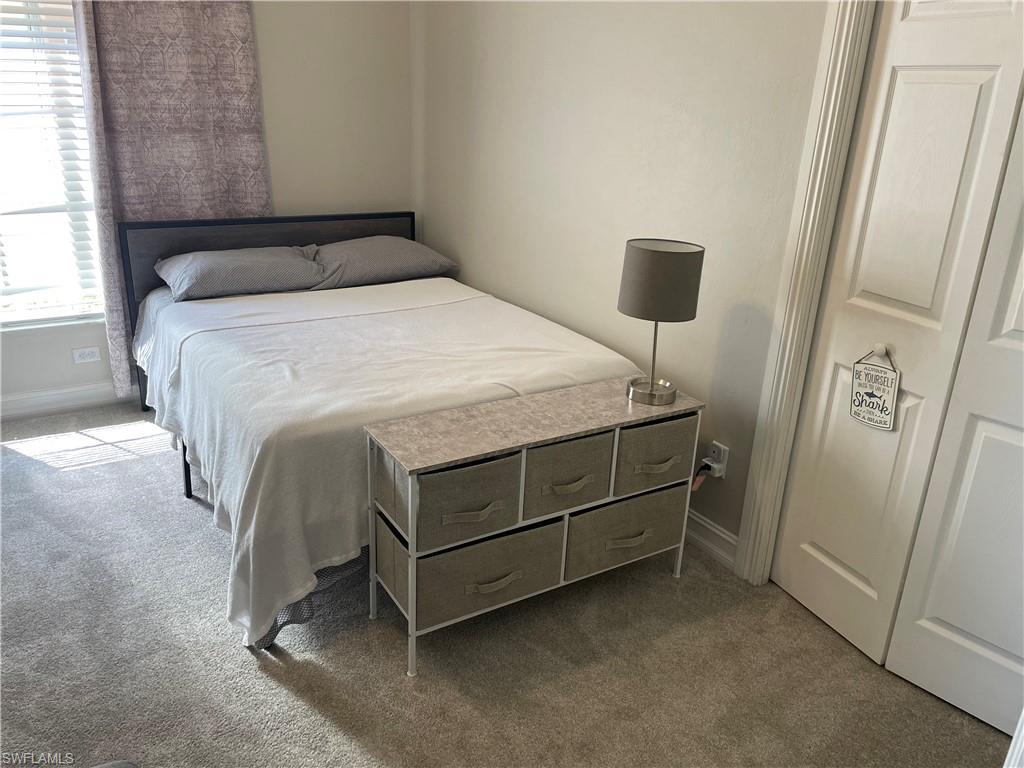 9195 Michael Circle, Unit 1301 Naples, FL 34113 - Photo 24 of 25 a bedroom with a bed and a mirror