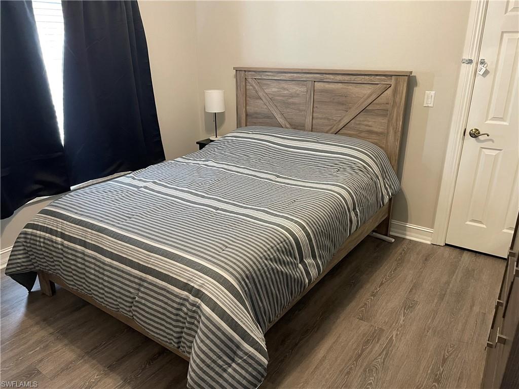 9195 Michael Circle, Unit 1301 Naples, FL 34113 - Photo 25 of 25 a bedroom with a bed and wooden floor