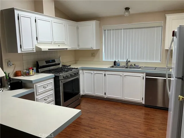 a kitchen with stainless steel appliances granite countertop a stove a sink dishwasher and a refrigerator