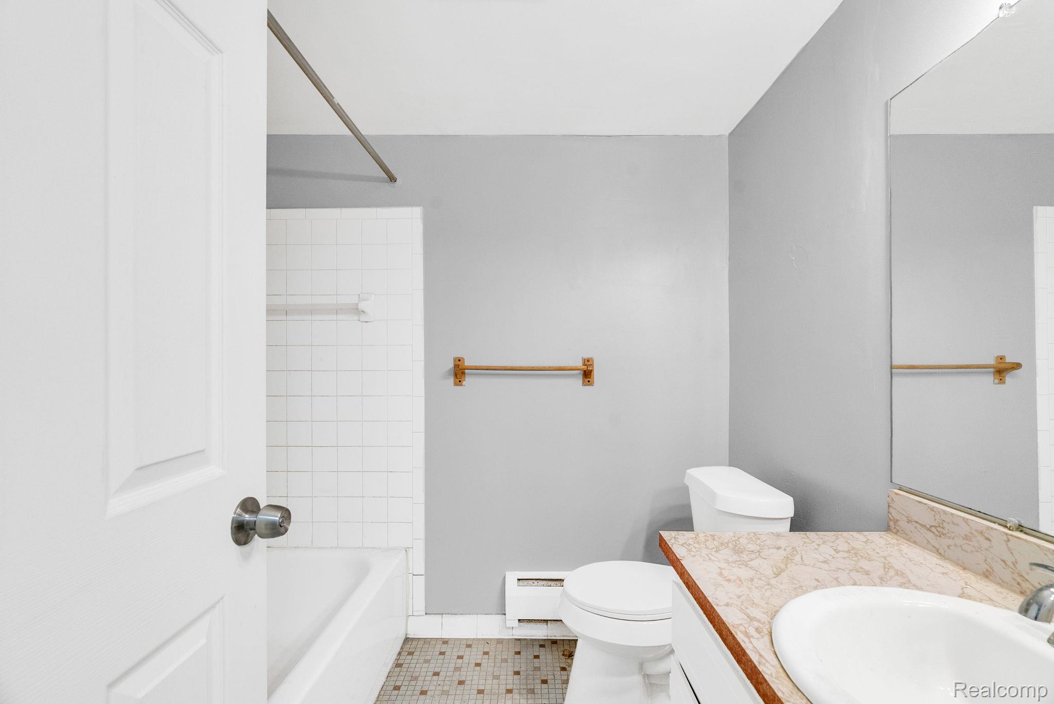 4535 Cadieux Road, Unit 42 / 210 Detroit, MI 48224 - Photo 16 of 16 Bathroom with vanity, washtub / shower combination, baseboard heating, and light tile patterned floors