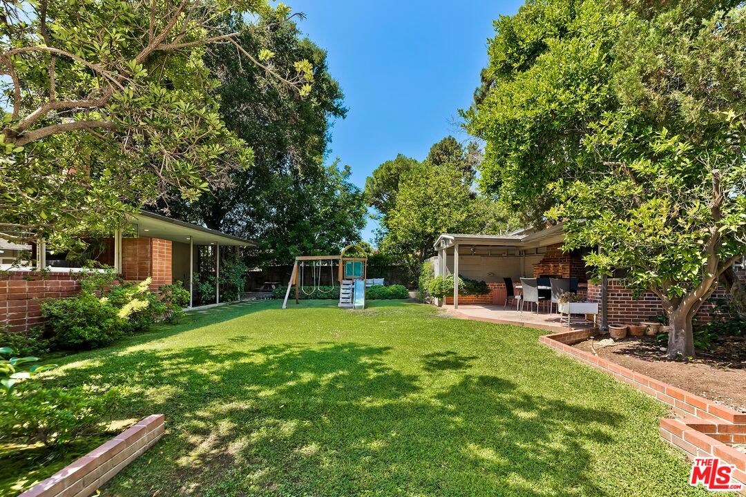 929 Mesa Verde Road Pasadena, CA 91105 - Photo 31 of 51 a view of a backyard with table and chairs potted plants and a large tree
