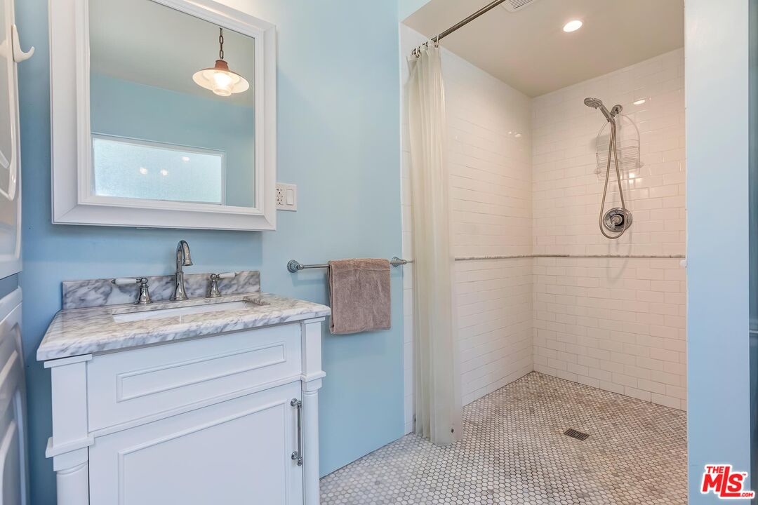 929 Mesa Verde Road Pasadena, CA 91105 - Photo 49 of 51 a bathroom with a granite countertop sink a mirror and a shower