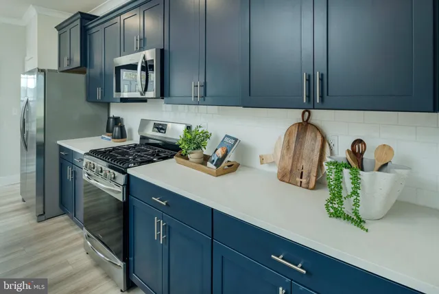 a kitchen with stainless steel appliances granite countertop a sink a stove and cabinets