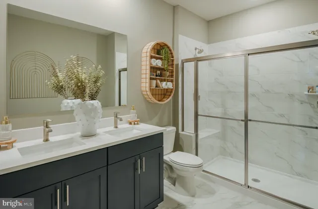 a bathroom with a toilet a sink a glass door shower and mirror
