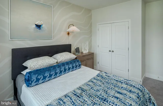 a bedroom with a bed and a painting on the wall