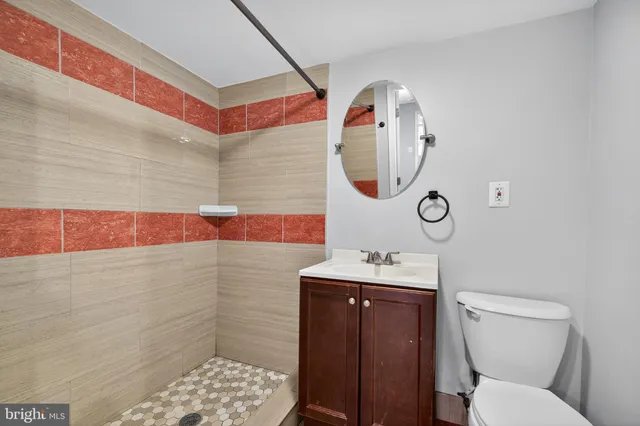 a bathroom with a toilet sink vanity and mirror
