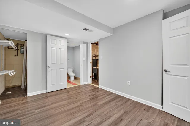 a view of a big room with wooden floor and windows