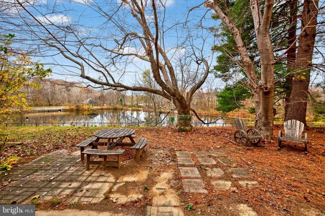 a backyard of a house with table and chairs under an umbrella