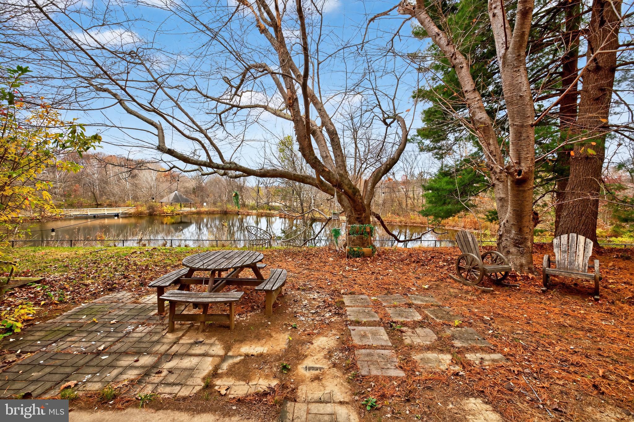 9961 Lake Landing Road Gaithersburg, MD 20886 - Photo 6 of 40 a backyard of a house with table and chairs under an umbrella
