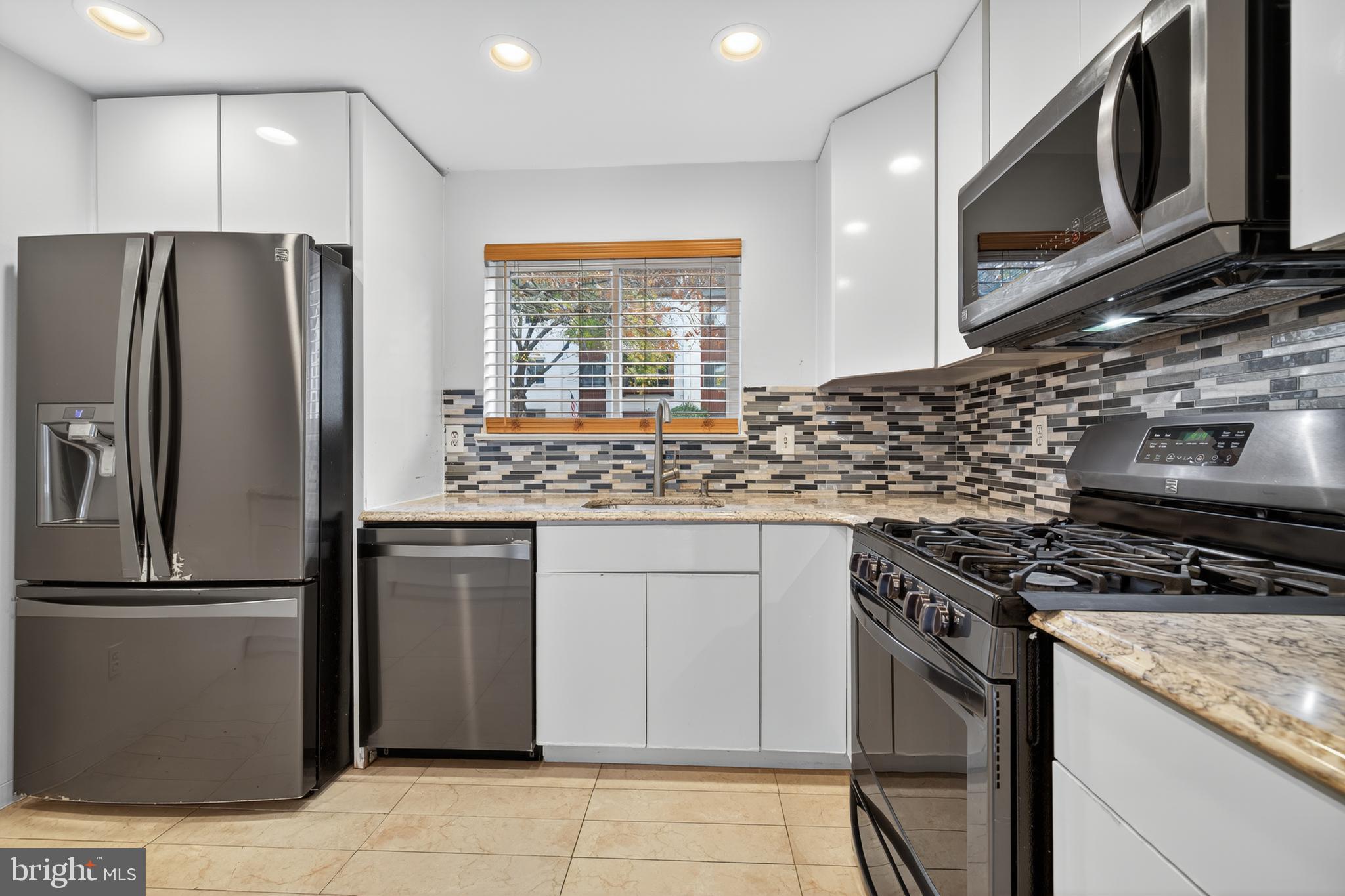 9961 Lake Landing Road Gaithersburg, MD 20886 - Photo 10 of 40 a kitchen with stainless steel appliances granite countertop a stove a refrigerator and a microwave